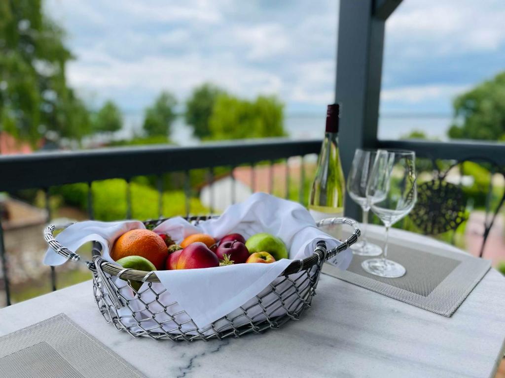 un cesto di frutta su un tavolo con una bottiglia di vino di HERBERGE SEENSUCHT Fewo MÜRITZ OG links a Göhren-Lebbin