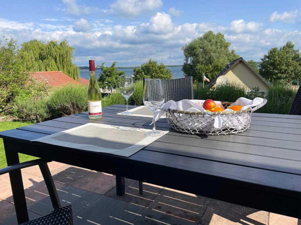 un tavolo con un cesto di frutta e una bottiglia di vino di HERBERGE SEENSUCHT Fewo FLEESENSEE EG links a Göhren-Lebbin