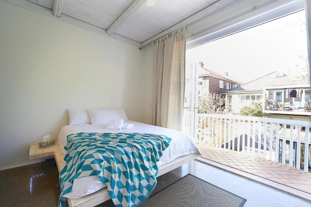 a bedroom with a bed on a balcony at Jet Flamingo in Sydney