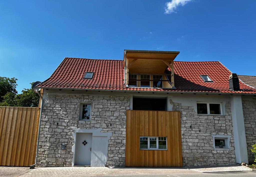 une maison en pierre avec un toit rouge et une porte dans l'établissement Scheune 65, à Bad Frankenhausen