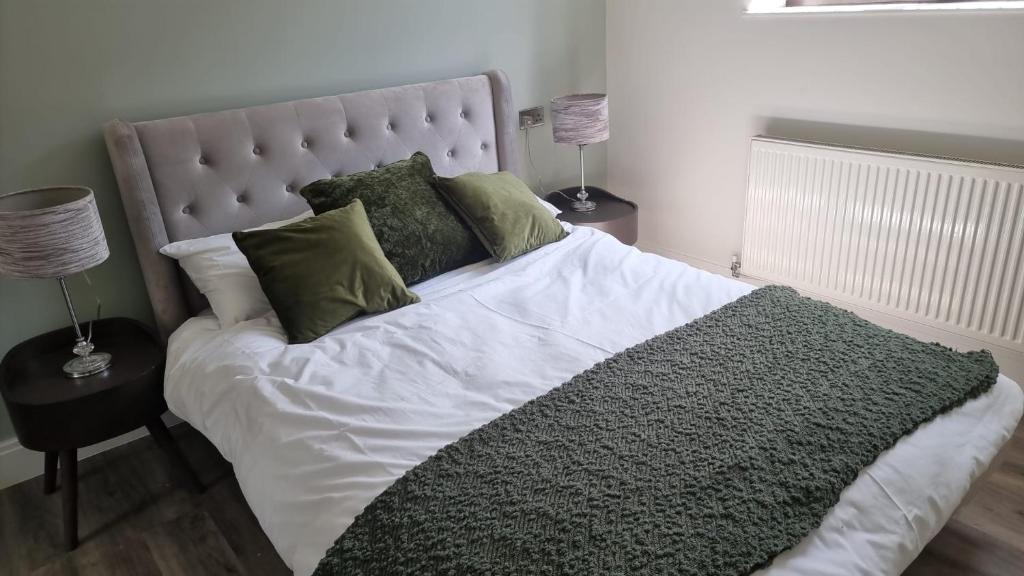 a bedroom with a large bed with green pillows at Jasmin Apartments - Luxury 1 & 2 Bedroom units with Free Parking in Bushey