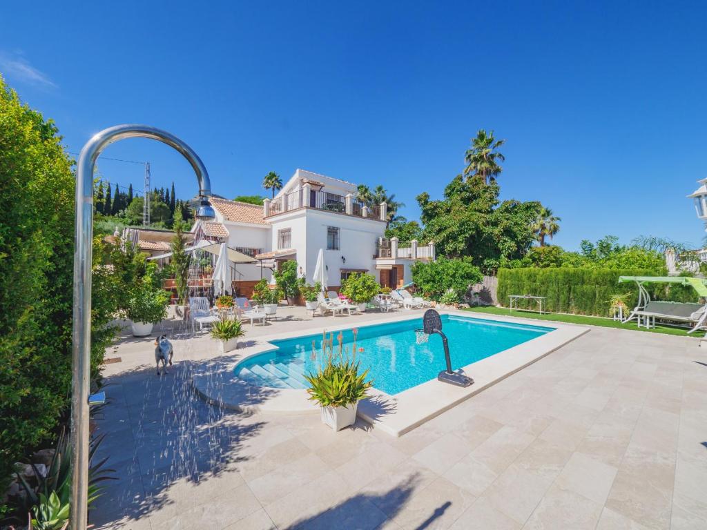 een groot huis met een zwembad in een tuin bij Cubo's Casa El Azahar in Alhaurín el Grande