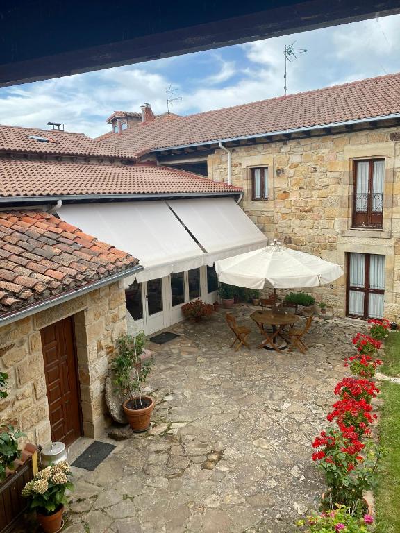 un patio con mesa y sombrilla en Peñasalve, en Villamoñico