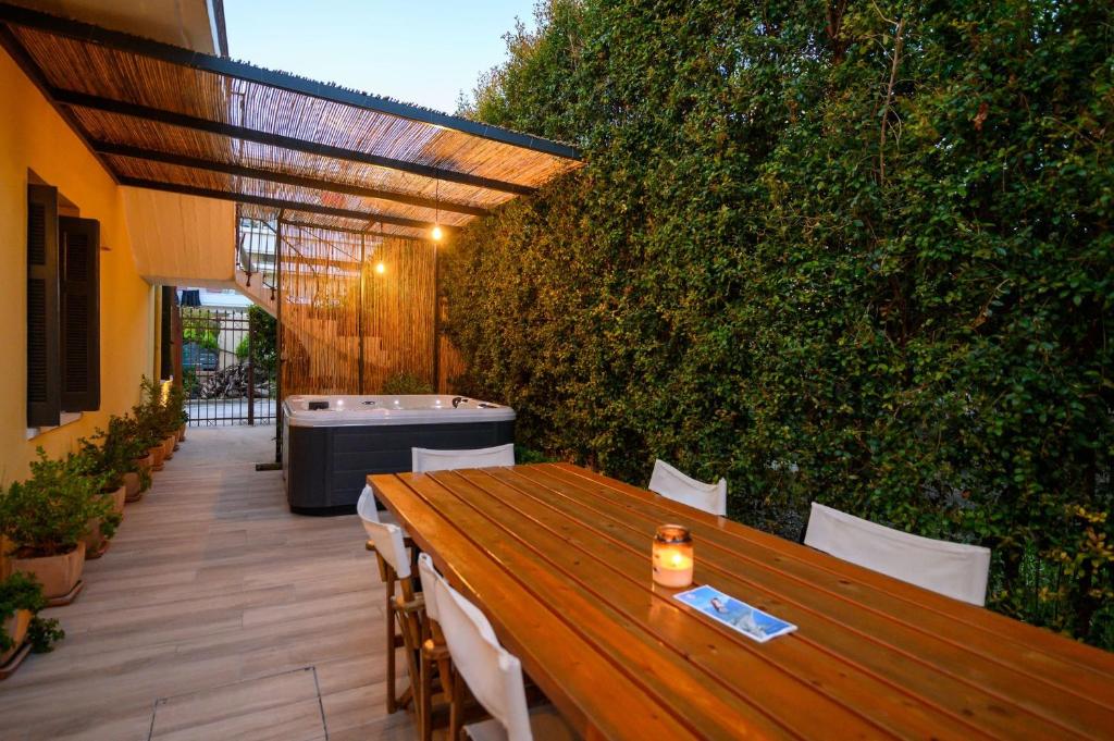 een patio met een houten tafel en een hot tub bij Linas Home - Kalamata Mediterranean Villas in Kalamata