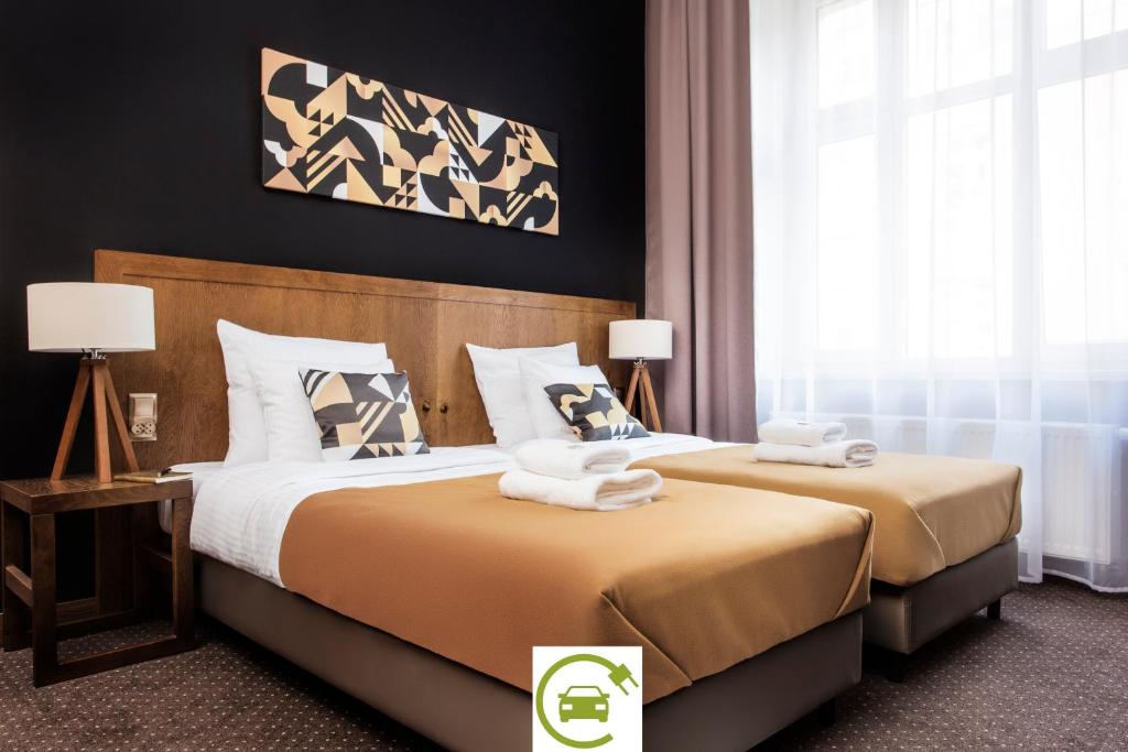 Habitación de hotel con 2 camas y toallas. en Zulian Aparthotel by Artery Hotels, en Cracovia