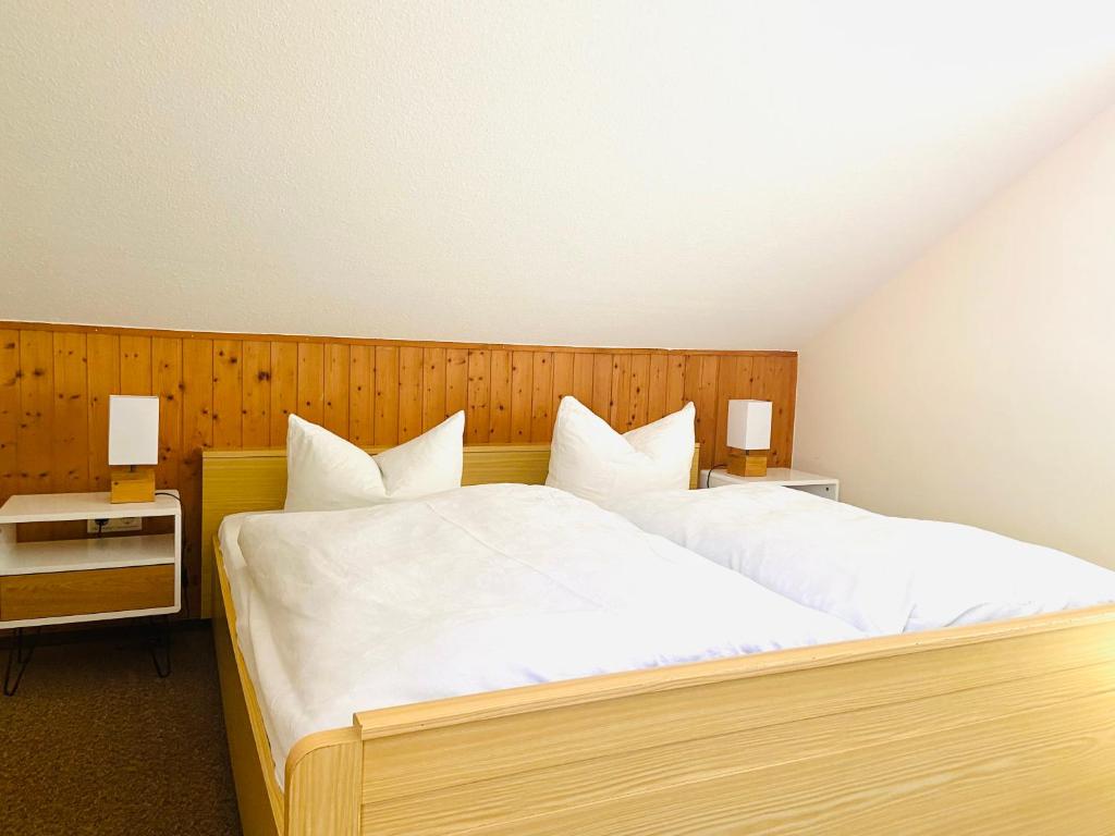ein Schlafzimmer mit einem großen Bett mit weißer Bettwäsche in der Unterkunft Forsterhof in Pottenstein