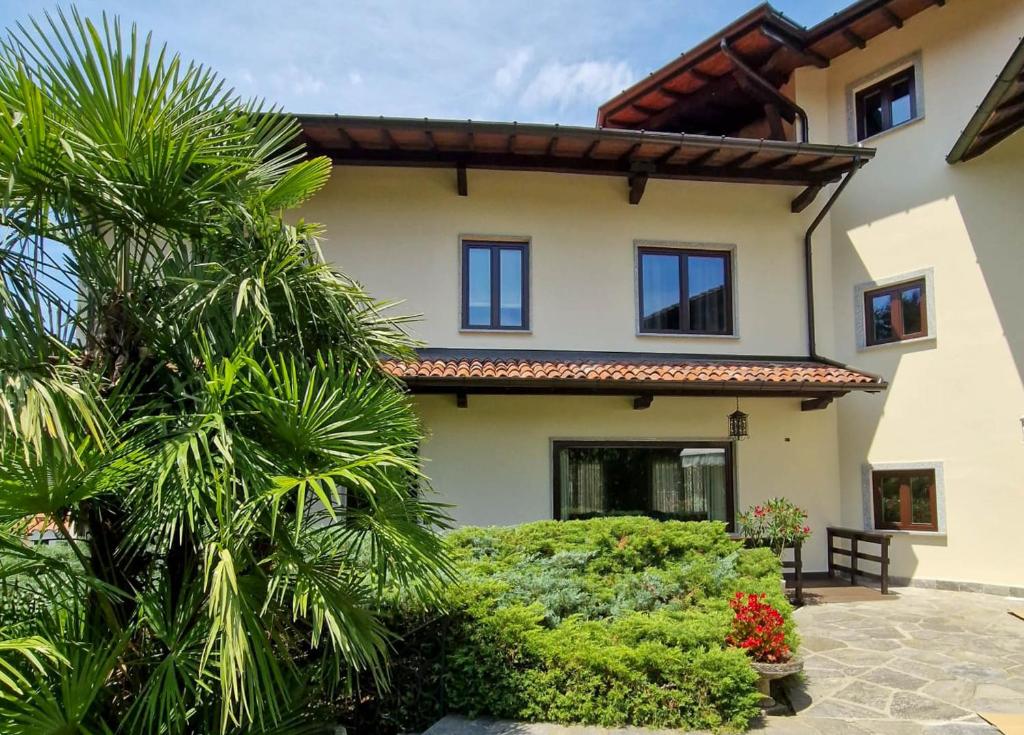 a house with palm trees in front of it at Villa Sarchi in Grantola