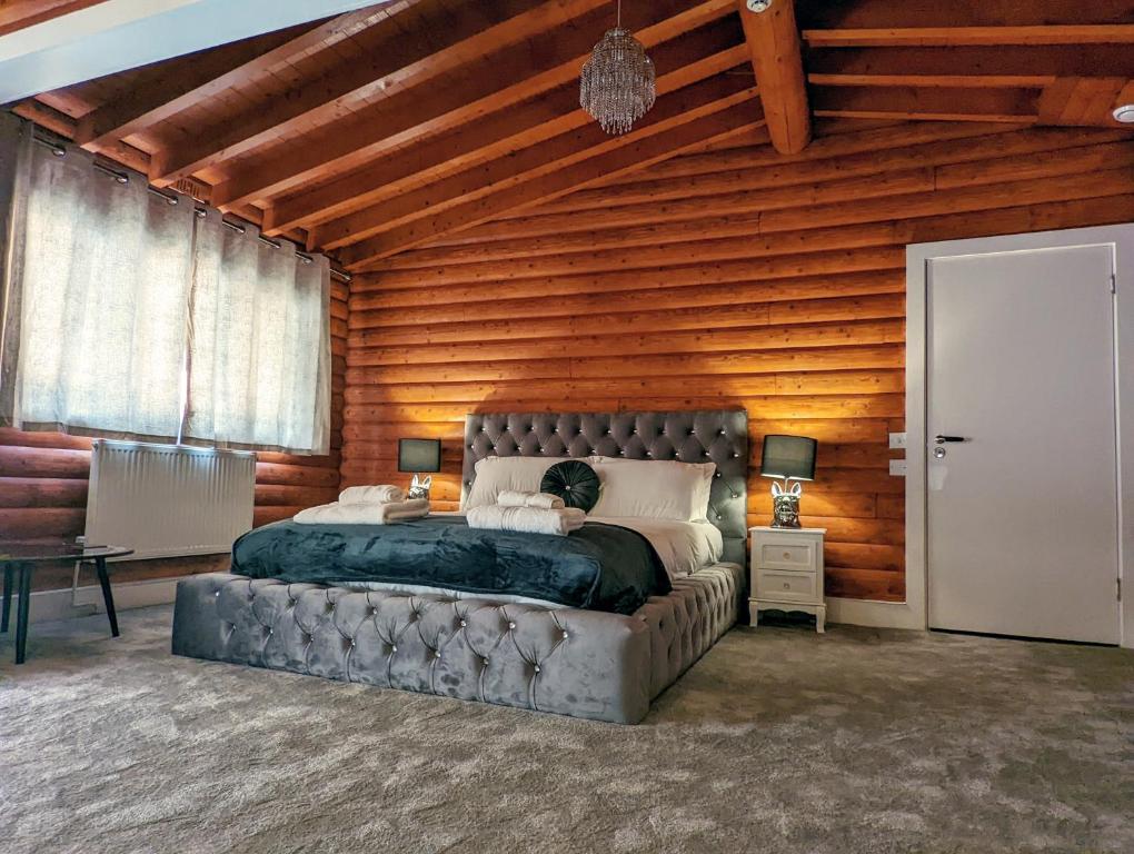 um quarto com uma cama e uma parede de madeira em Kaoglen-Blossom-Hot tub-Cairngorms-Pet Friendly em Balnald