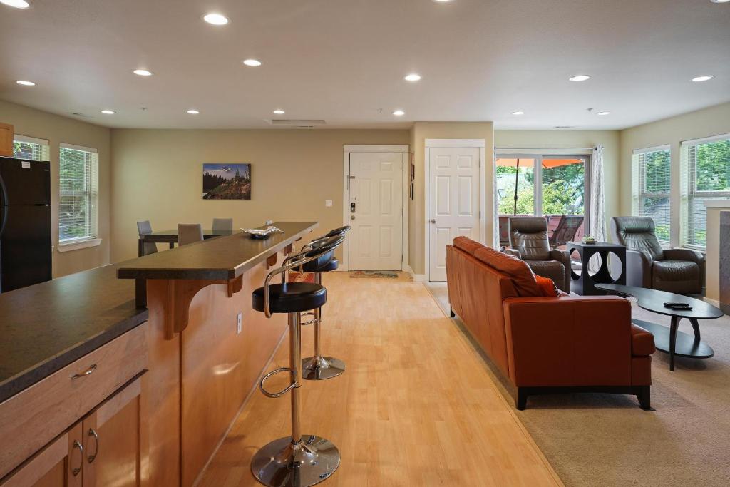 a kitchen with a bar and a living room at Downtowner Apartment in Bend
