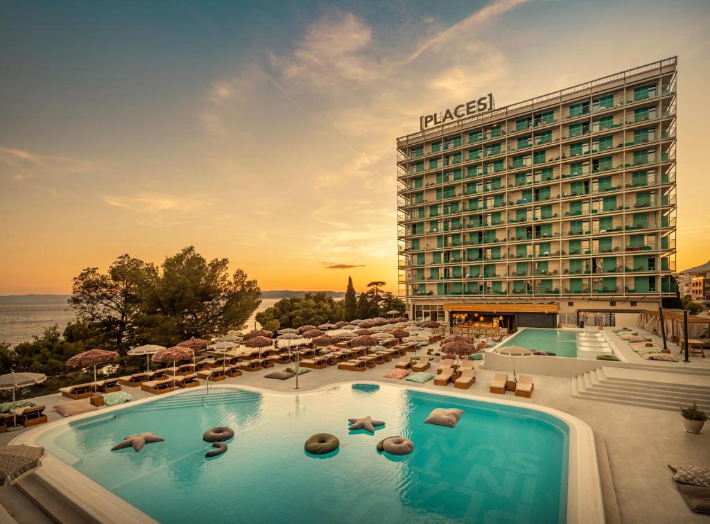 un hôtel avec une grande piscine et un hôtel dans l'établissement DALMACIJA PLACES HOTEL by Valamar, à Makarska