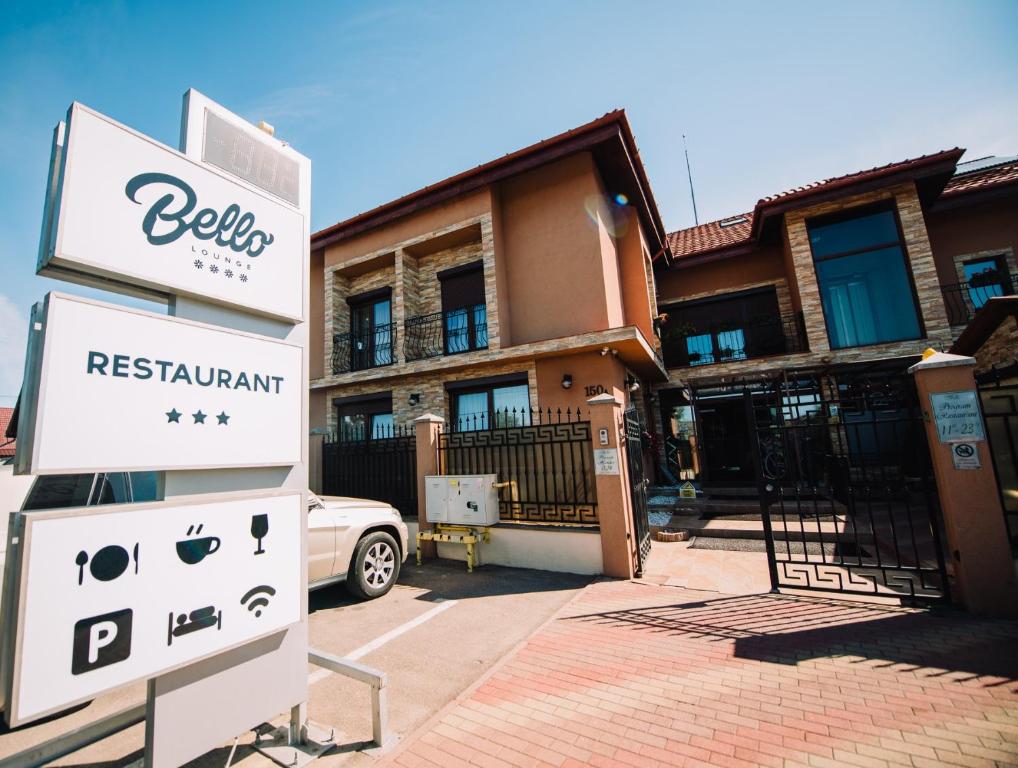 a house with a sign in front of it at Pensiunea Bello in Marghita