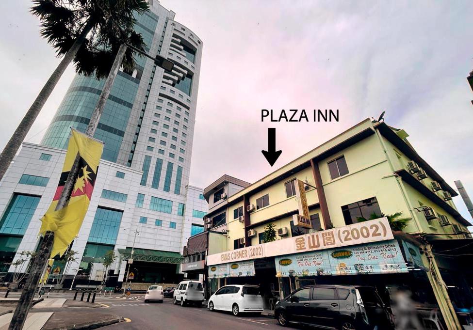 a city street with cars parked in front of buildings at Plaza Inn in Sibu