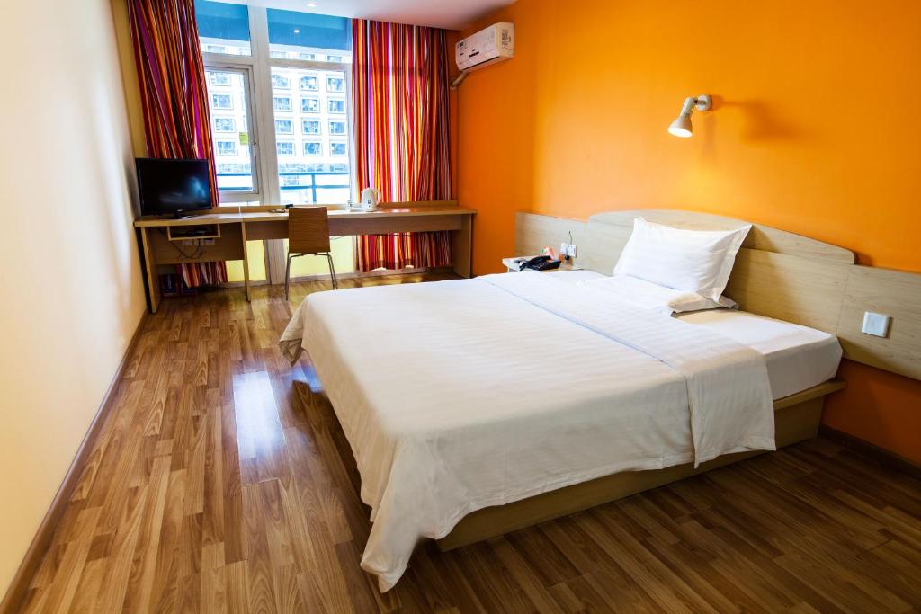 a hotel room with a large bed and a desk at 7Days Inn Premium Beijing Chaoyangmen in Beijing
