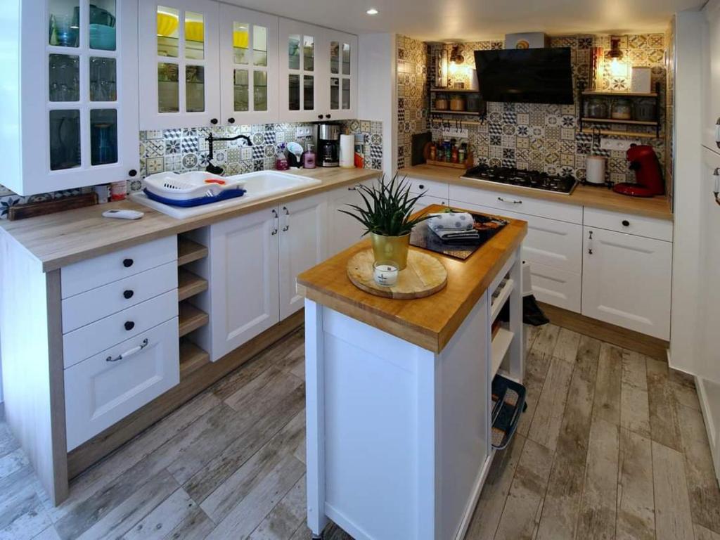 a large kitchen with white cabinets and a island at La Bulle Bleue futuroscope in Chasseneuil-du-Poitou