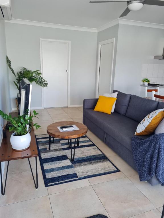 Alkion Villa في واجا واجا: غرفة معيشة مع أريكة زرقاء وطاولة