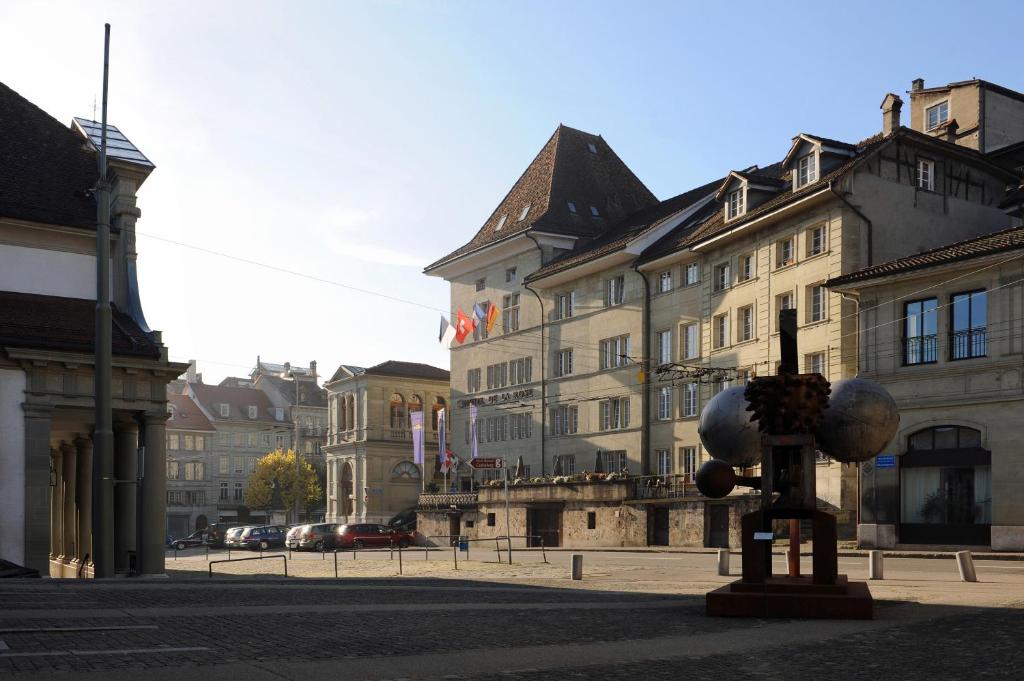 Una statua in mezzo a una strada con edifici di Hôtel de la Rose a Friburgo