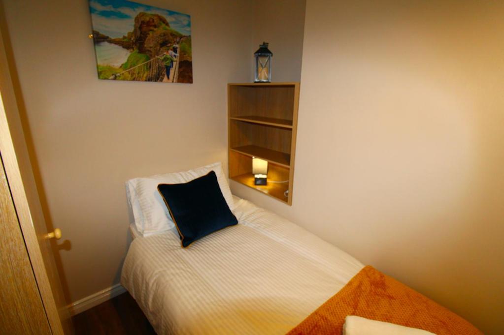a small bedroom with a bed with a pillow on it at Beulah Guest House in Portrush