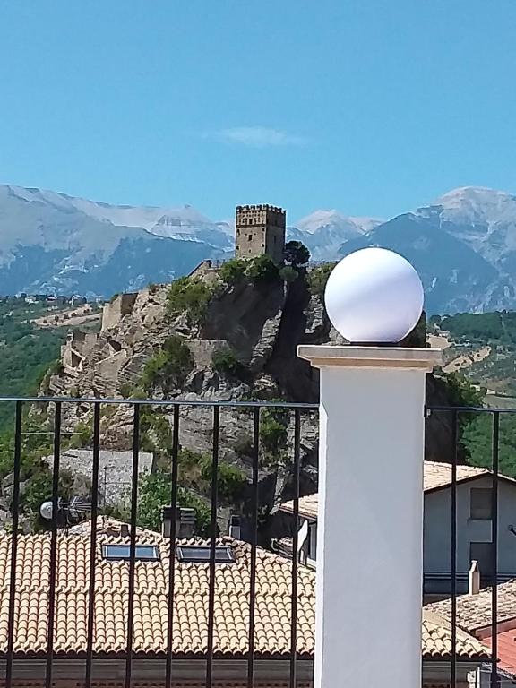 a castle on top of a hill with a fence at Primae Noctis Rooms in Apartments in Roccascalegna