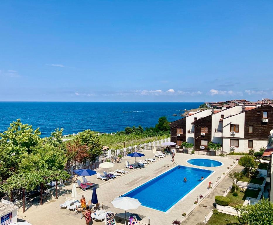 a view of a swimming pool and the ocean at Apolon Complex in Sozopol