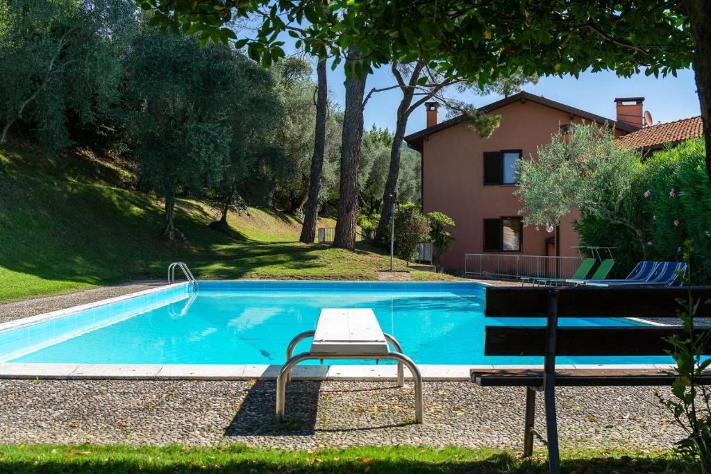 a swimming pool with a chair next to a house at CASA ELLSA in Tremezzo