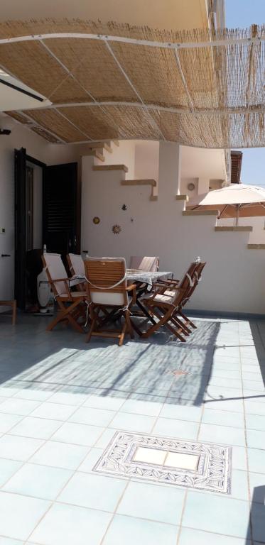 a room with chairs and a table on a tiled floor at Villetta Le Maldive Del Salento in Marina di Pescoluse