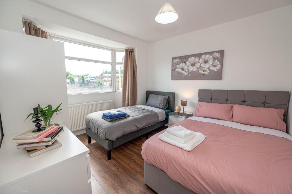 a bedroom with a bed and a couch and a window at 4 bedrooms,2 bathrooms house with free parking in Plumstead