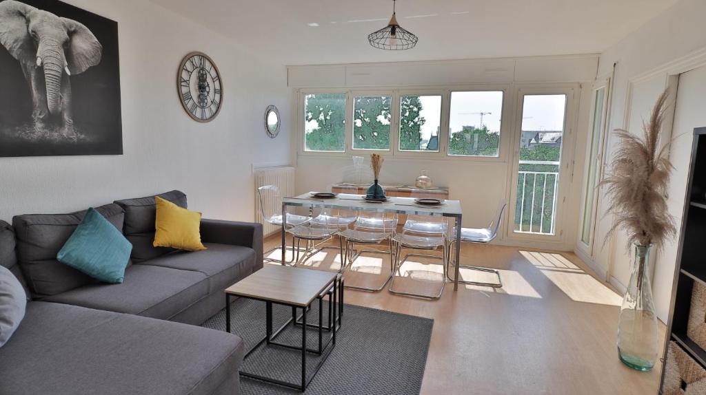 un salon avec un canapé et une table avec des chaises dans l'établissement Spacieux appartement avec Balcons, 4 chambres, espace & confort, Centre Gare, à Rennes