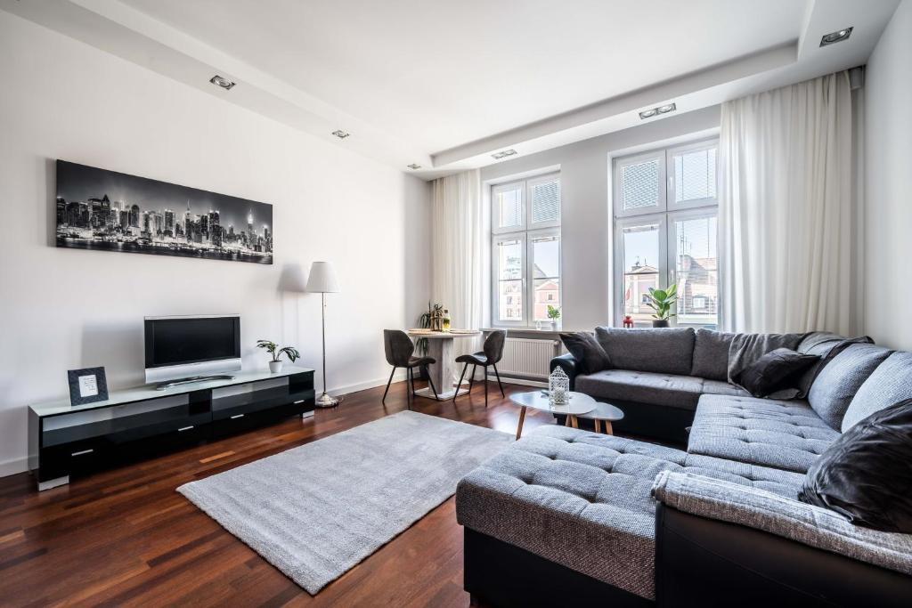 a living room with a couch and a table at Rynek 45 Apartament in Wrocław