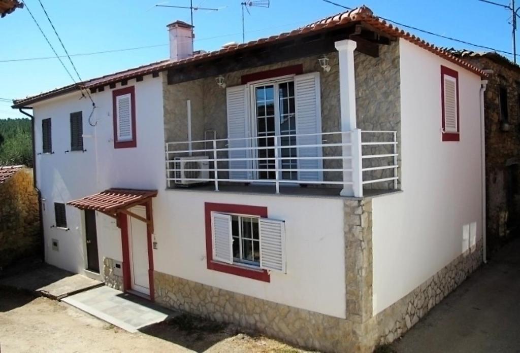 ein Haus mit einem Balkon an der Seite in der Unterkunft Zen Guest House em Leiria in Pedrógão Grande