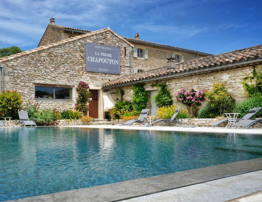 a swimming pool in front of a building at La Ferme Chapouton - Teritoria in Grignan
