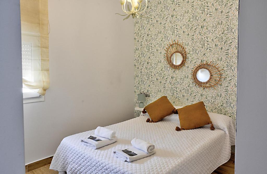 セビリアにあるApartamento Trianaのベッドルーム1室(ベッド1台、タオル2枚、鏡付)