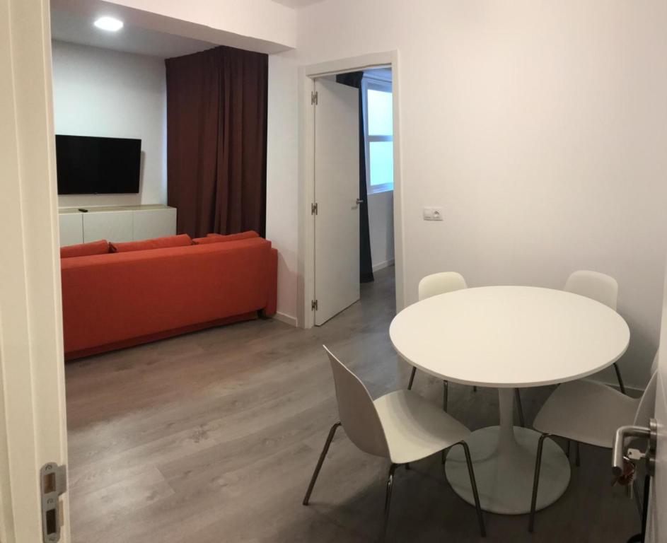 a living room with a couch and a table and chairs at Nest Flats Santiago VUT in Santiago de Compostela