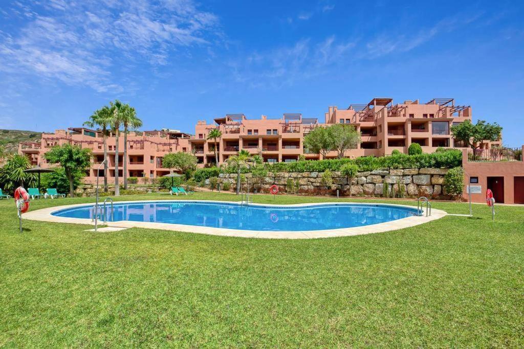 a swimming pool in front of a large building at Estrella de Mar zeezicht en uitkijk op Gibraltar 40m2 terras incl zwembad Las Garzas Manilva in Manilva