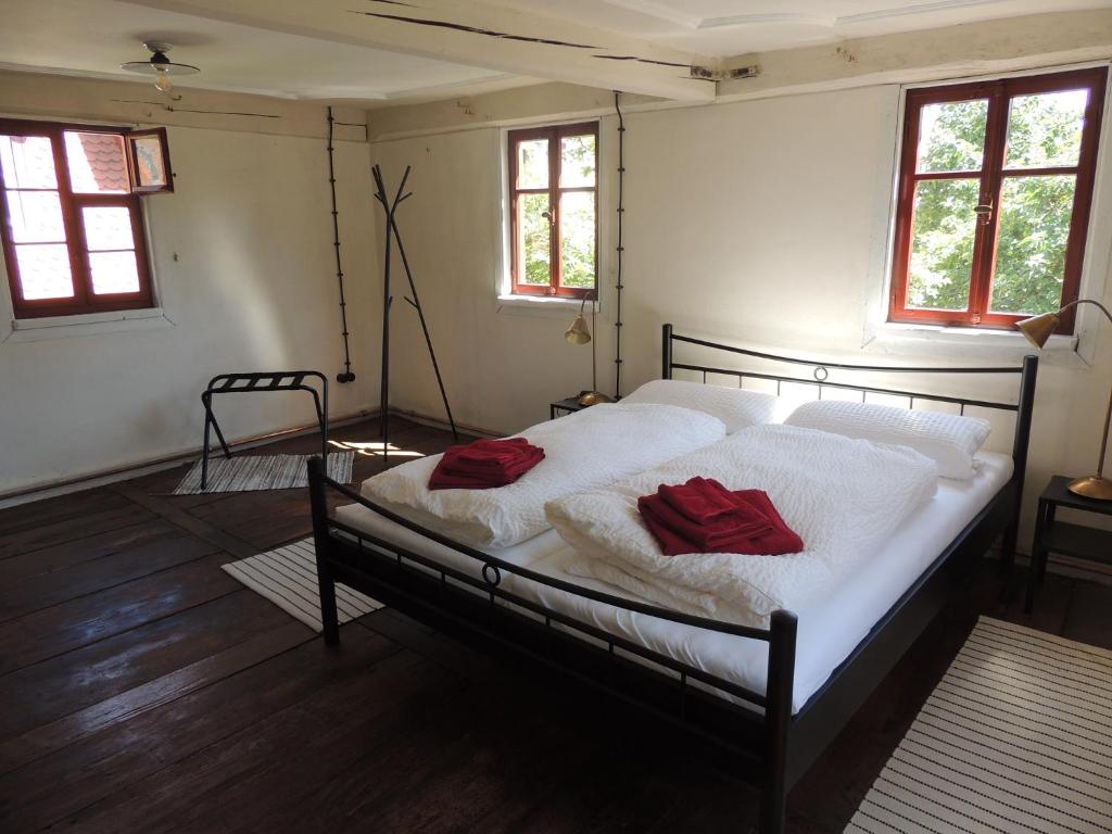 a bedroom with a bed with two red pillows on it at Pilger- und Radlerherberge Herberge im Hofhaus in Colmberg