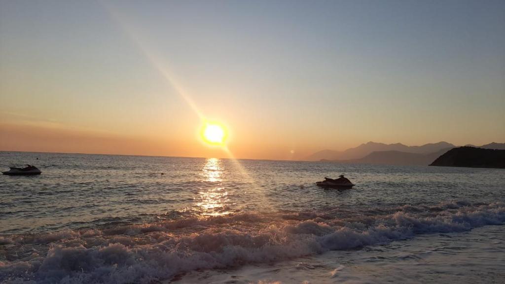 two people in boats in the ocean at sunset at Eva's House in Lukovë