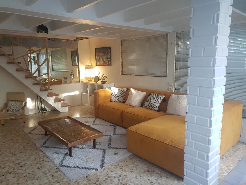 un soggiorno con un divano e un tavolo di Maison bord de Marne 8min disneyland et val d'Europe a Chalifert