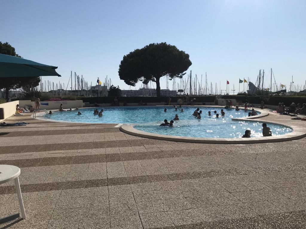 un groupe de personnes dans une piscine dans l'établissement Sol-y-Days Escale Port, Agréable studio au RDC, résidence avec piscine entre la plage nord et Port Camargue, au Grau-du-Roi