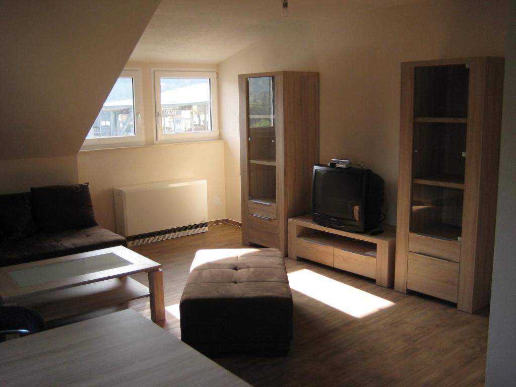 a living room with a couch and a tv at Haus Beate Groß in Kröv