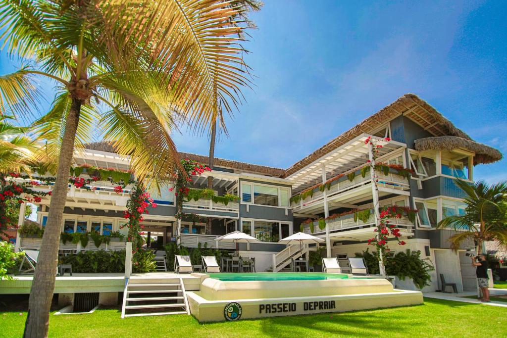 a large building with a palm tree in front of it at Depraia Apartments in Icaraí