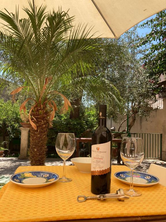 a bottle of wine sitting on a table with glasses at House with Garden in Noto