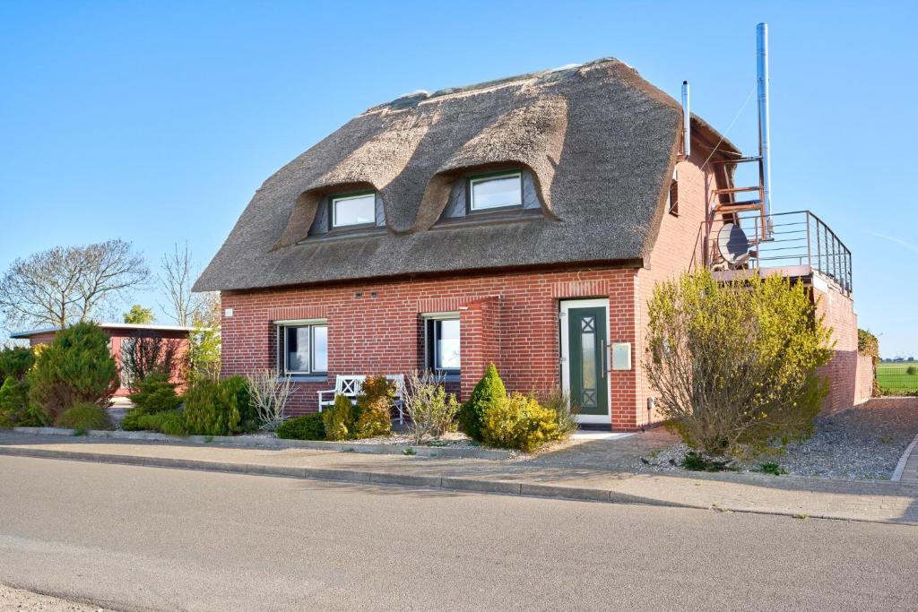 a red brick house with a shingled roof at Suedwind in Nordstrand