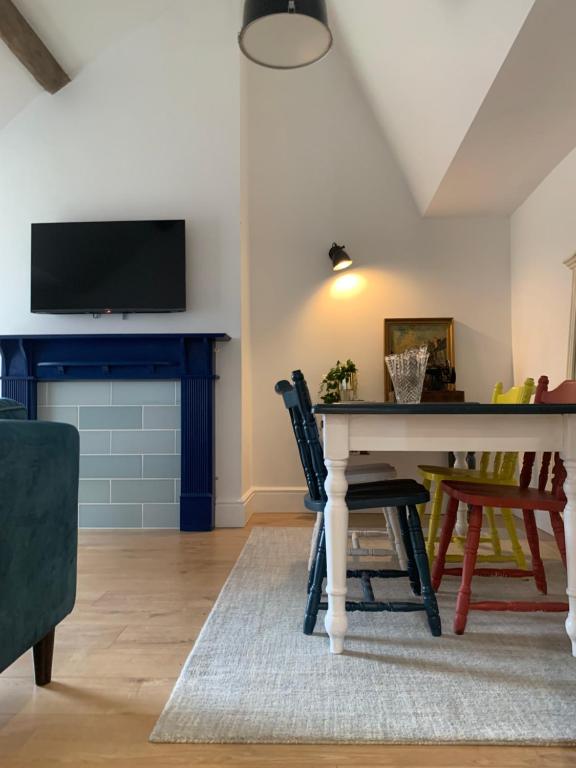 a living room with a table and a tv at Bespoke Luxury Serviced Apartment in Macclesfield