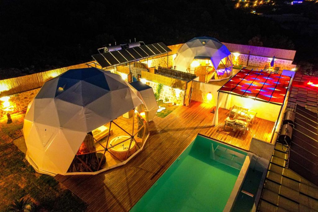 einen Ausblick über ein Haus mit Pool in der Nacht in der Unterkunft Kalkan Dome Suites & Deluxe-Glamping Holiday in Kalkan in Kaş
