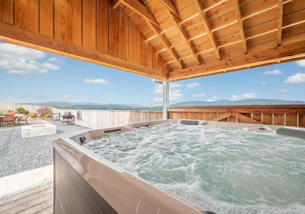 a hot tub on the deck of a house at Ynys Cadno in Trawsfynydd