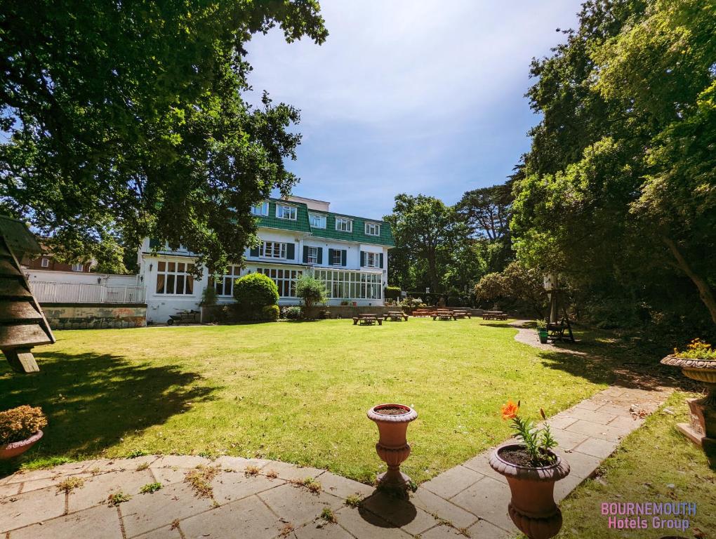 a large building with a yard with flowers in the grass at The Grove Hotel in Bournemouth