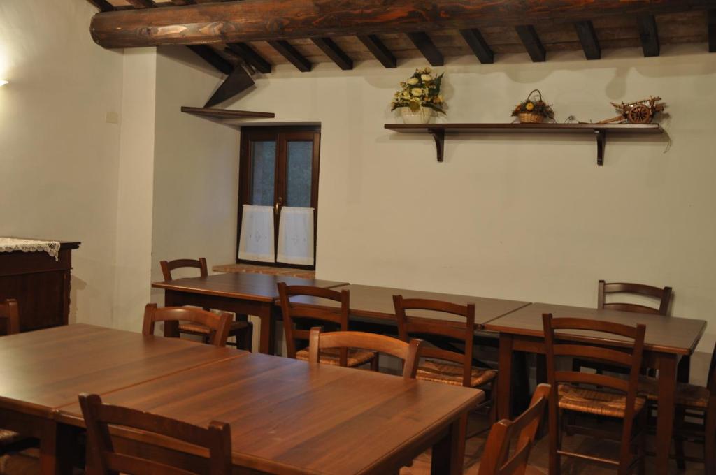 une salle à manger avec des tables et des chaises en bois dans l'établissement Farmstay Agriturismo La Fonte, à Belforte del Chienti