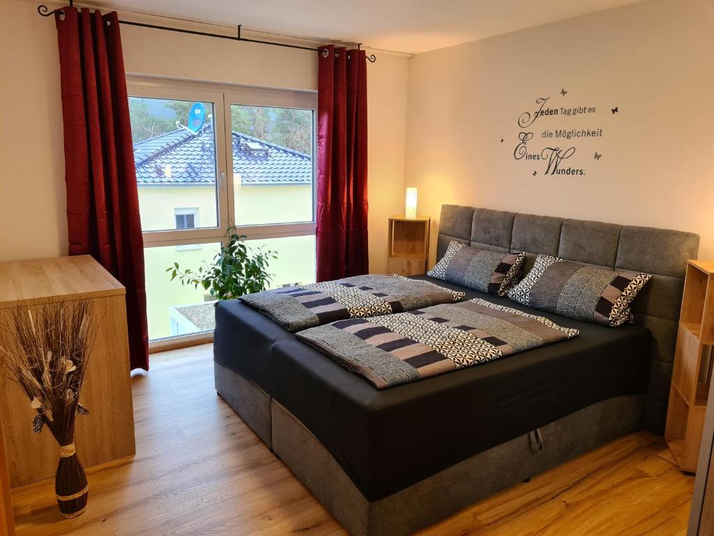 1 dormitorio con cama y ventana grande en FeWo Brombachsee - Sonnentag Süd, en Röttenbach