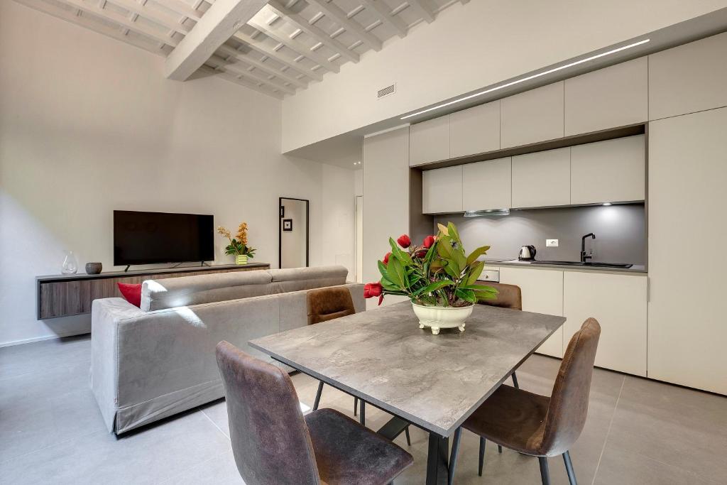 a living room with a table and a couch at Mamo Florence - Venere & Zefiro Apartments in Florence