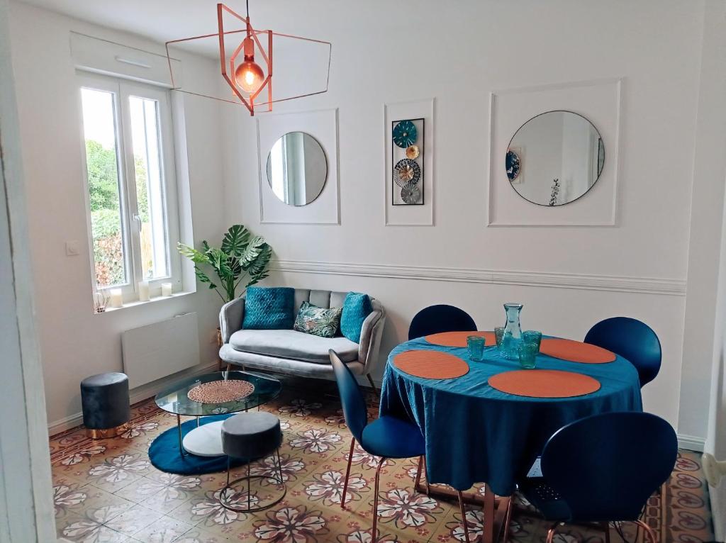 uma sala de estar com uma mesa azul e cadeiras em Irziana - Au jardin d'Henriville em Amiens