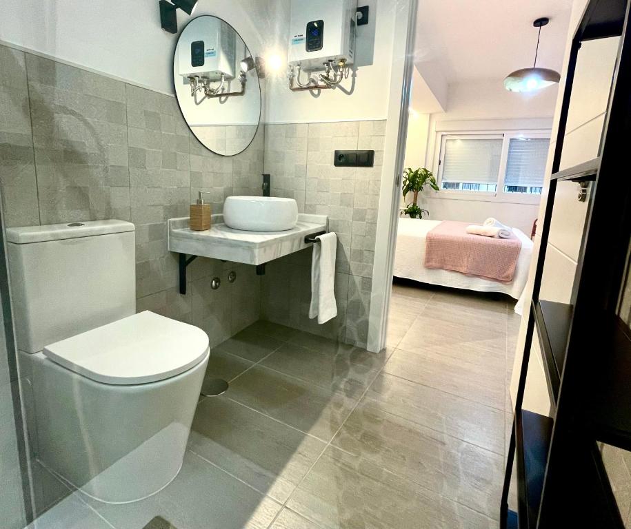 La salle de bains est pourvue de toilettes blanches et d'un lavabo. dans l'établissement Carmen viejo 12, à Sanlúcar de Barrameda
